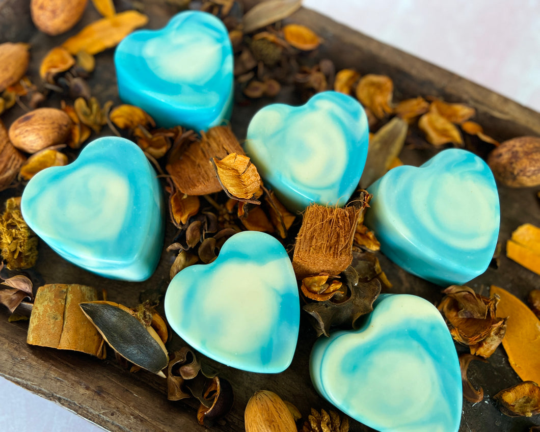 6 blue and white swirled soaps sit on top of a bed of potpourri.