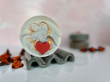 Load image into Gallery viewer, Six frostedA grey soap with a red heart and gold mica sits on top of a soap dish. In the background are 2 more soaps stacked on each other. 